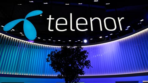 telenor white sign in black background, blue stage