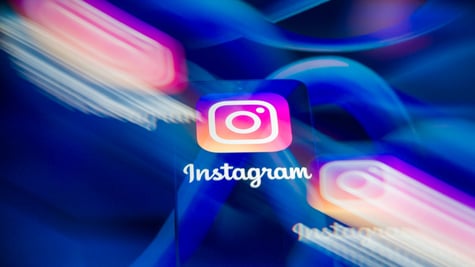 three instagram logos, two blurry, meta logos, the blue infinity signs, in the background