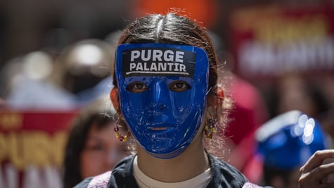 Anti-ICE demonstrator with mask saying "Purge Palantir"