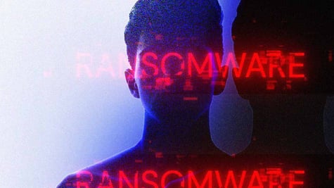Person with letters spelling ransomware in a dark background
