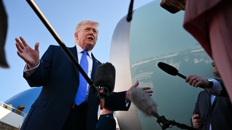 donald trump, bright blue tie, white shirt, sea blue plane turbine, black microphones, clear sky