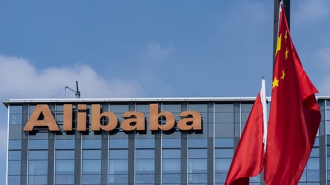alibaba orange signage atop glass building, blue sky, white cloud, two china's flags