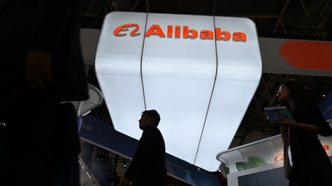 alibaba booth, white glowy sign, orange letters, two black silhouettes of asian male and female