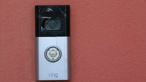 amazon ring doorbell camera, grey and black, red wall