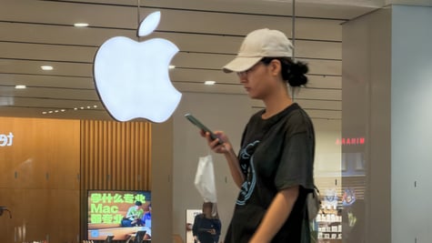 white asian woman ,sand color hat, black ponytail, apple logo