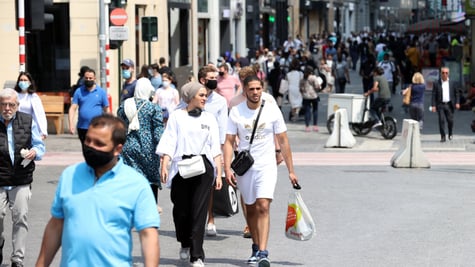sunny day, grey pavement, blue t-shirt- blue face mask, white shirts, shopping bag, white shorts
