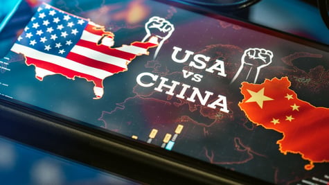 A tablet screen depicts maps of the US and China raising their fists against one another