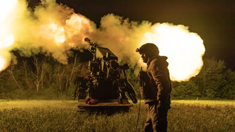 ukrianian soldier in uniform, helmet, white male, night time field, explosion artilery