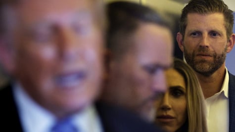 Eric Trump faded in the background behind President Trump and Melania, plus others.