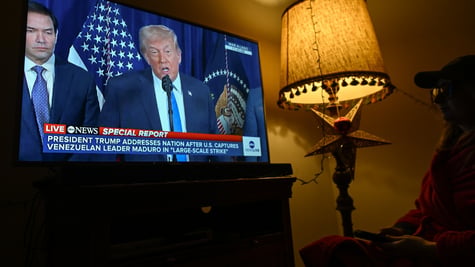 warm light floor lamp, donald trump on big tv screen, dark room, blue tie, white collar shirt