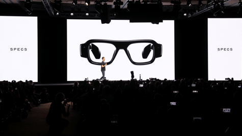 three huge white screens, black glasses, spiegel, white male in stage, black frames