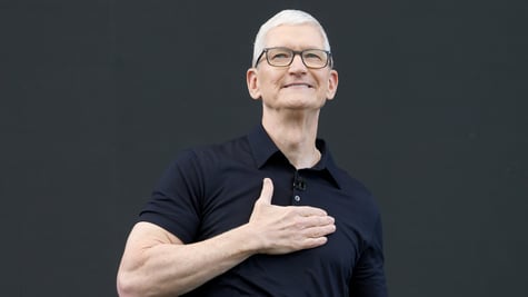 Apple CEO Tim Cook, right hand on heart, white male, grey white hair, left hand on heart