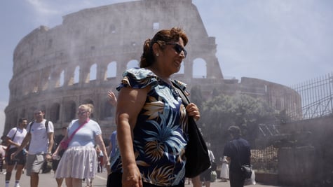 heat wave, elderly white tanned woman, rome's colosseum, sprinkles of water in the air, blue sky