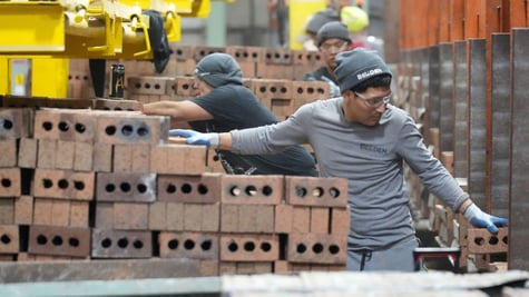 Workers package and cube pallet bricks, grey outfits