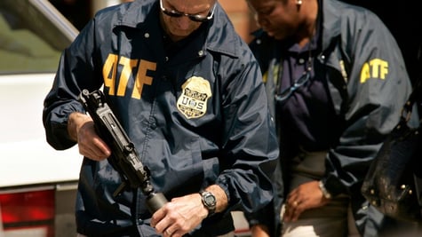 2 ATF agents wearing jackets with logo holding guns