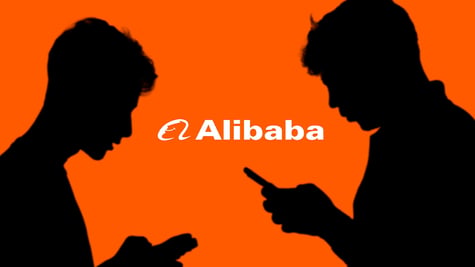 Two individuals looking at their smartphones with Alibaba logo in the background