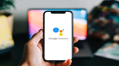 Hand holding phone with Google Assistant