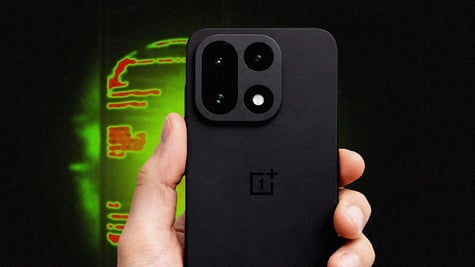 OnePlus 15 smartphone held in hand with a black and green backdrop.