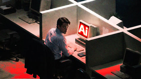 Man sitting in front of PC saying "AI", and looking back, mischief in his face, in dark office