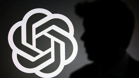 The silhouette of Sam Altman and OpenAI logo
