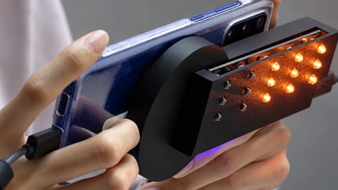 A hand holding a smartphone with SweepLED technology used to detect hidden cameras