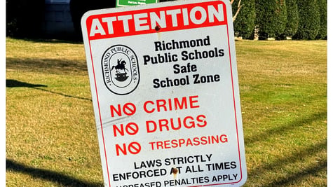 Richmond City Public School sign in forefront, high school in background