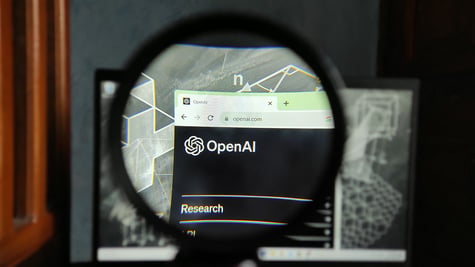 OpenAI logo seen through magnifying glass.