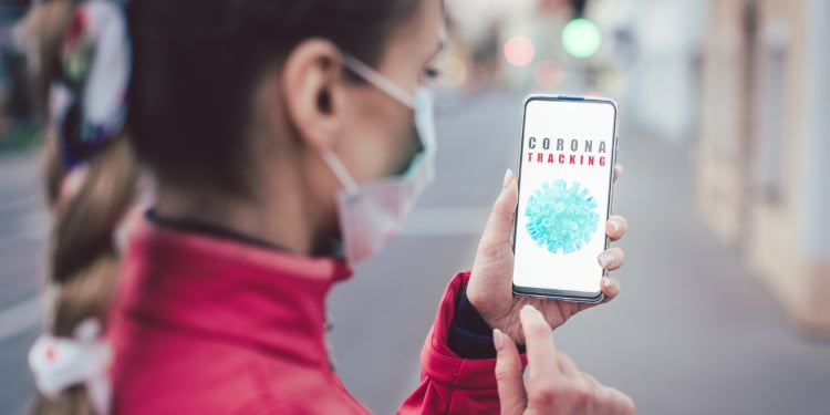 Woman using a phone with the coronavirus tracking app installed