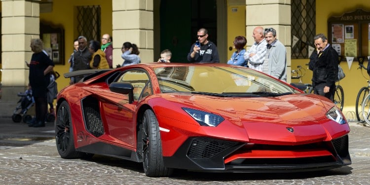 Red Lamborghini and people around it