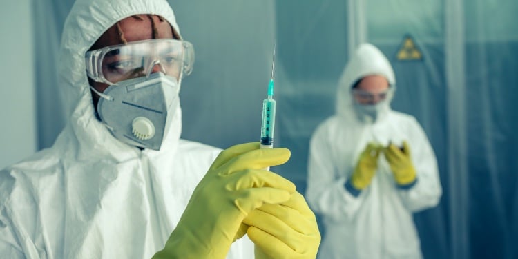 Doctor preparing syringe with virus vaccine to treat a patient