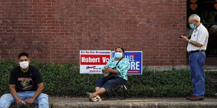 People wait in line to cast their ballots for the upcoming presidential election as early voting beg