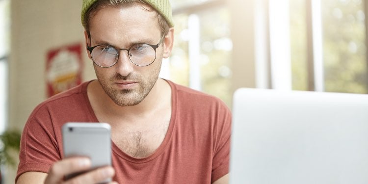 hipster staring at a smartphone
