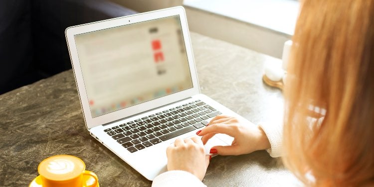 Woman using laptop with blurred screen