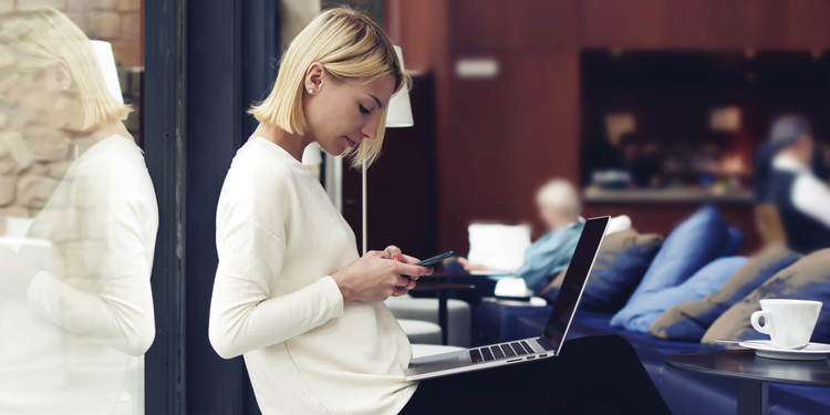 Woman with phone in front of her PC