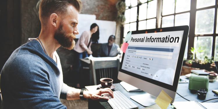 Young man looking at PC screen with Personal Information inscription