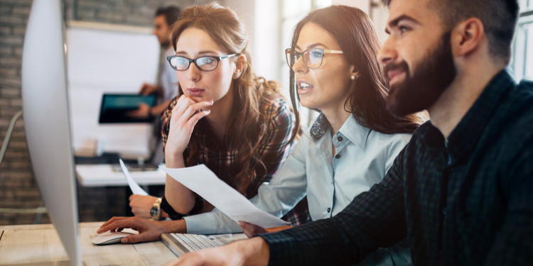 Group of employees looking at PC screen