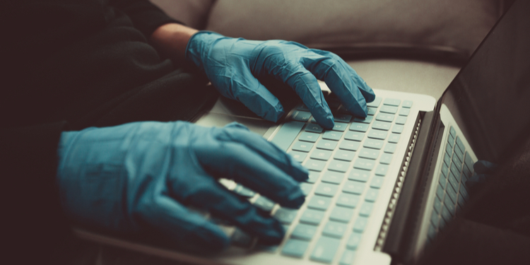 Person with gloves typing keyboard