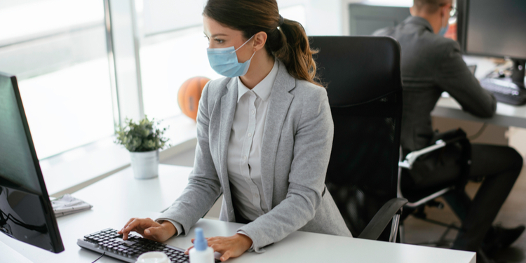 Businesswoman with medical mask working in office