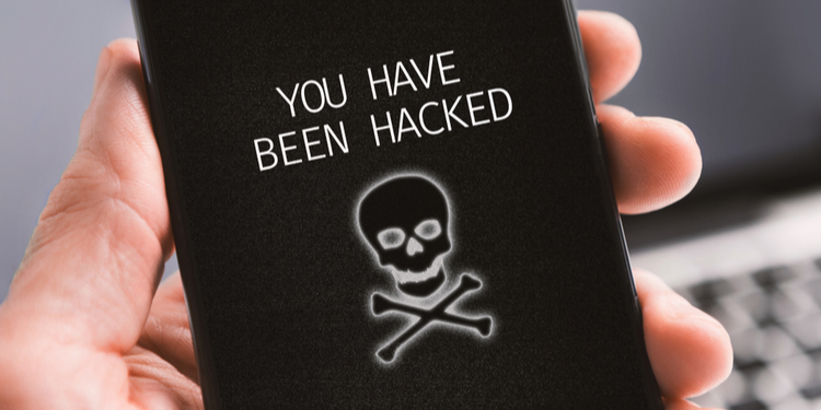 Haker alert concept. Modern smartphone with you have been hacked notification on screen in male's ha