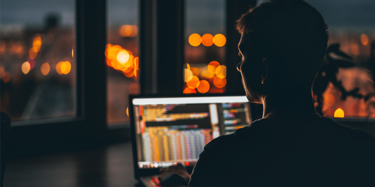 hacker in from of a computer in a dark room