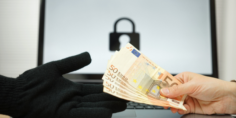 Black gloved hand taking 50 euro notes from bare hand with computer in background