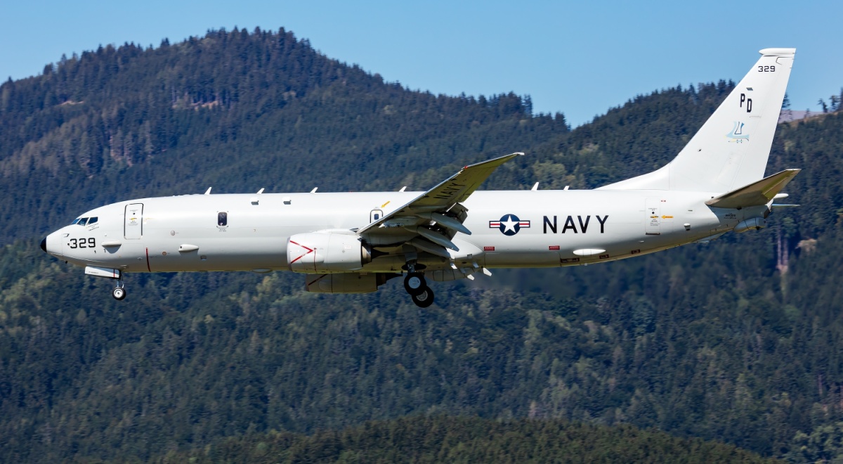 Military plane in air with US Navy logo
