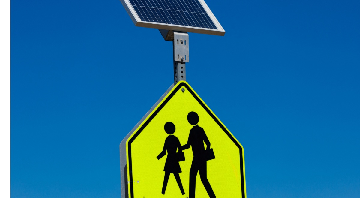 yellow traffic sign, woman and daughter silluet walking, solar power battery