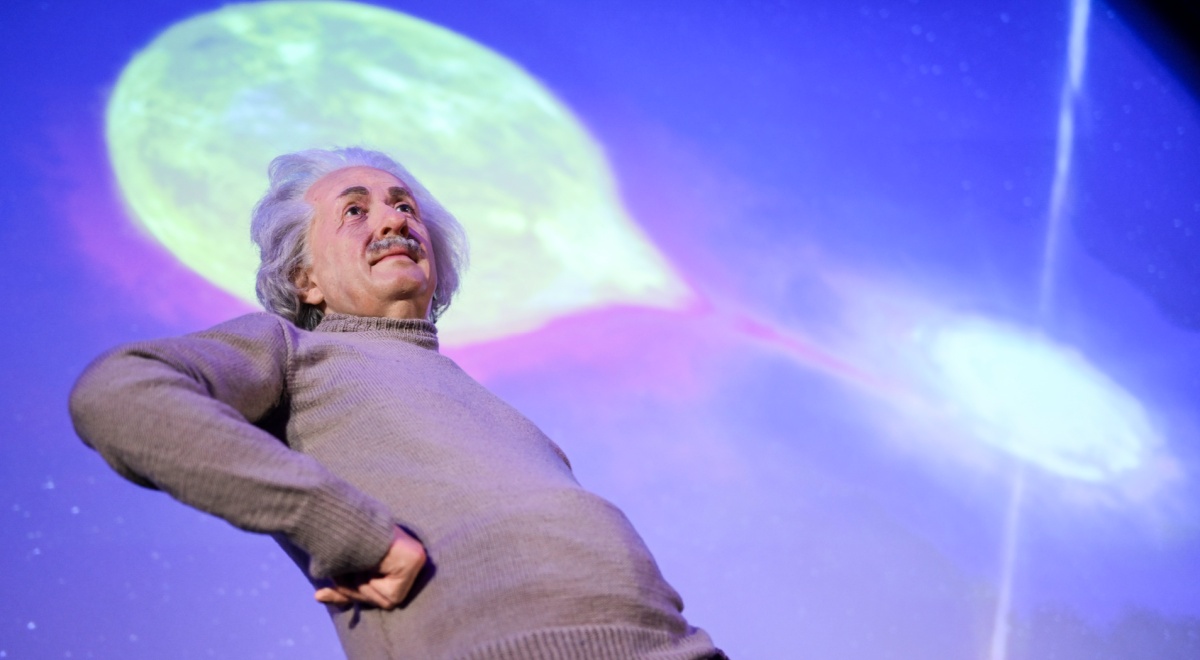 A wax model of Einstein next to a black hole exhibit.