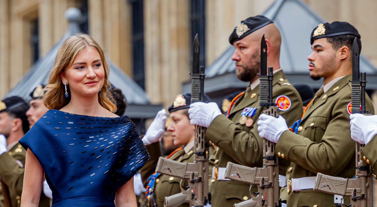 Princess Elisabeth of Belgium, blond hair, two army men in uniform, black guns, blue dress