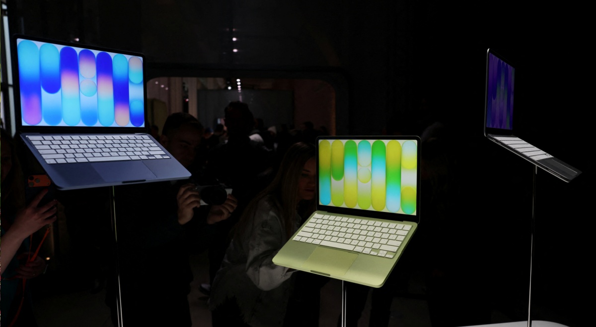 2 Apple MacBooks, left one blue, purple screen, right one green, orange screen, slightly lower