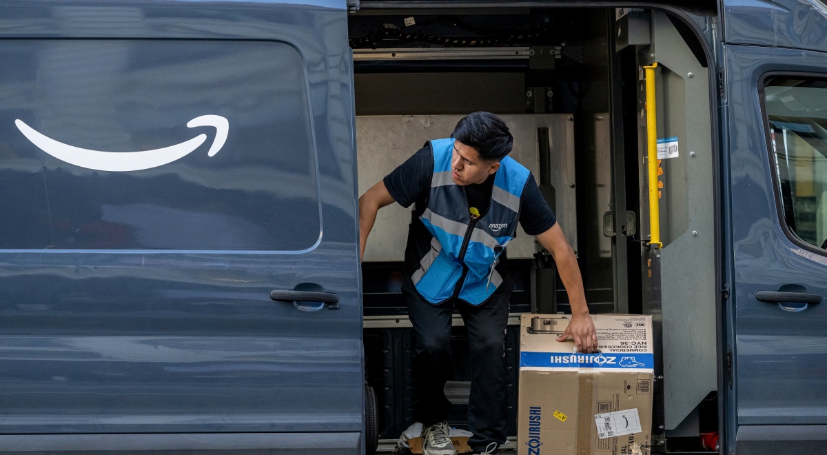 asian man, amazon vest, black hair, brown box, Zojirushi , dark blue amazon delivery trck