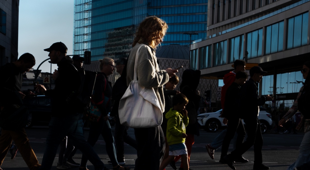 young woman, white handbag, smartphone, curly hair, pedestrians, crosswalk, berlin, shadowy