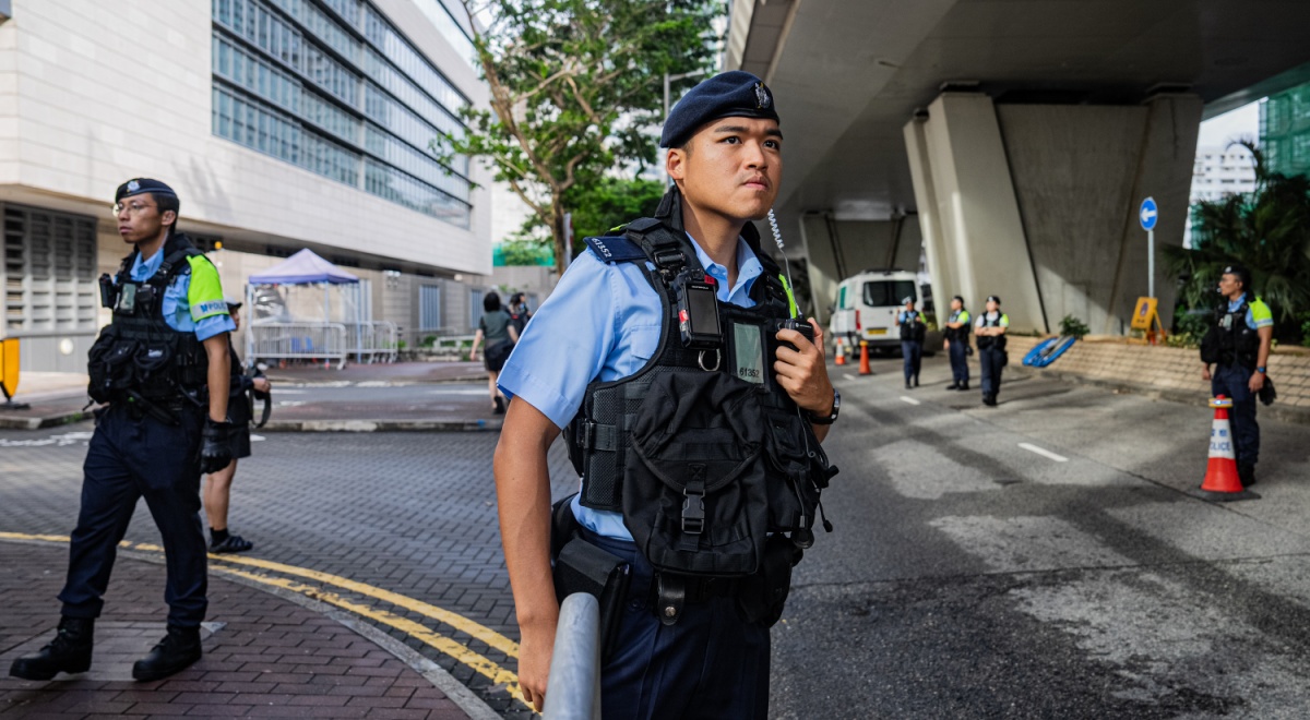 hong kong police officer, black bulletproof west, young asian man, blue short sleeve shirt