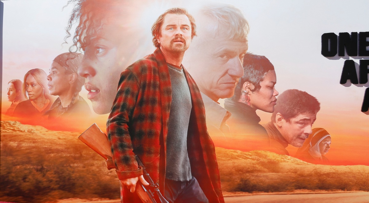leonardo di caprio in red and white flannel shirt, shotgun, sunset, orange field, road